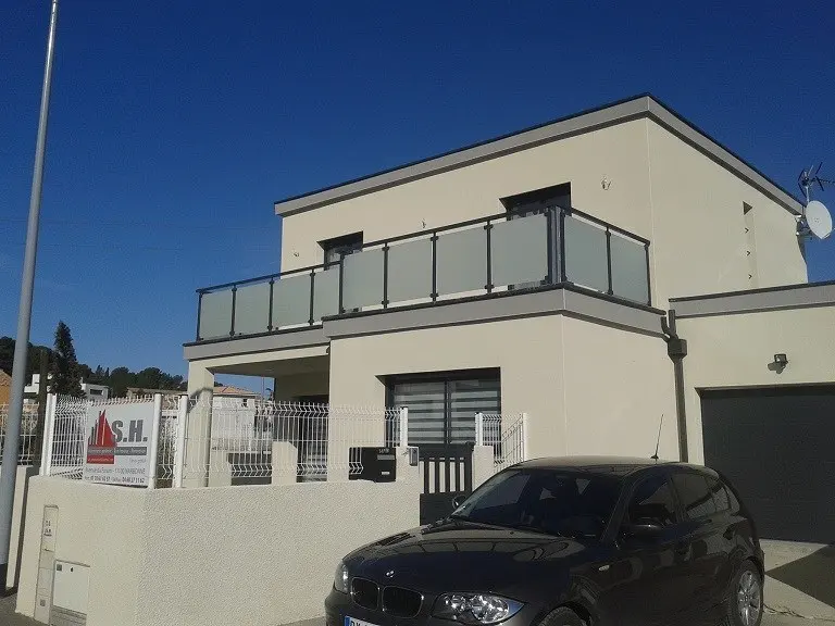 Metal railing with glass infill on the terrace of a detached house