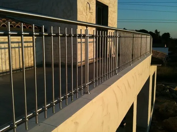 Teras kenarında ince dikey çubuklu metal korkuluk